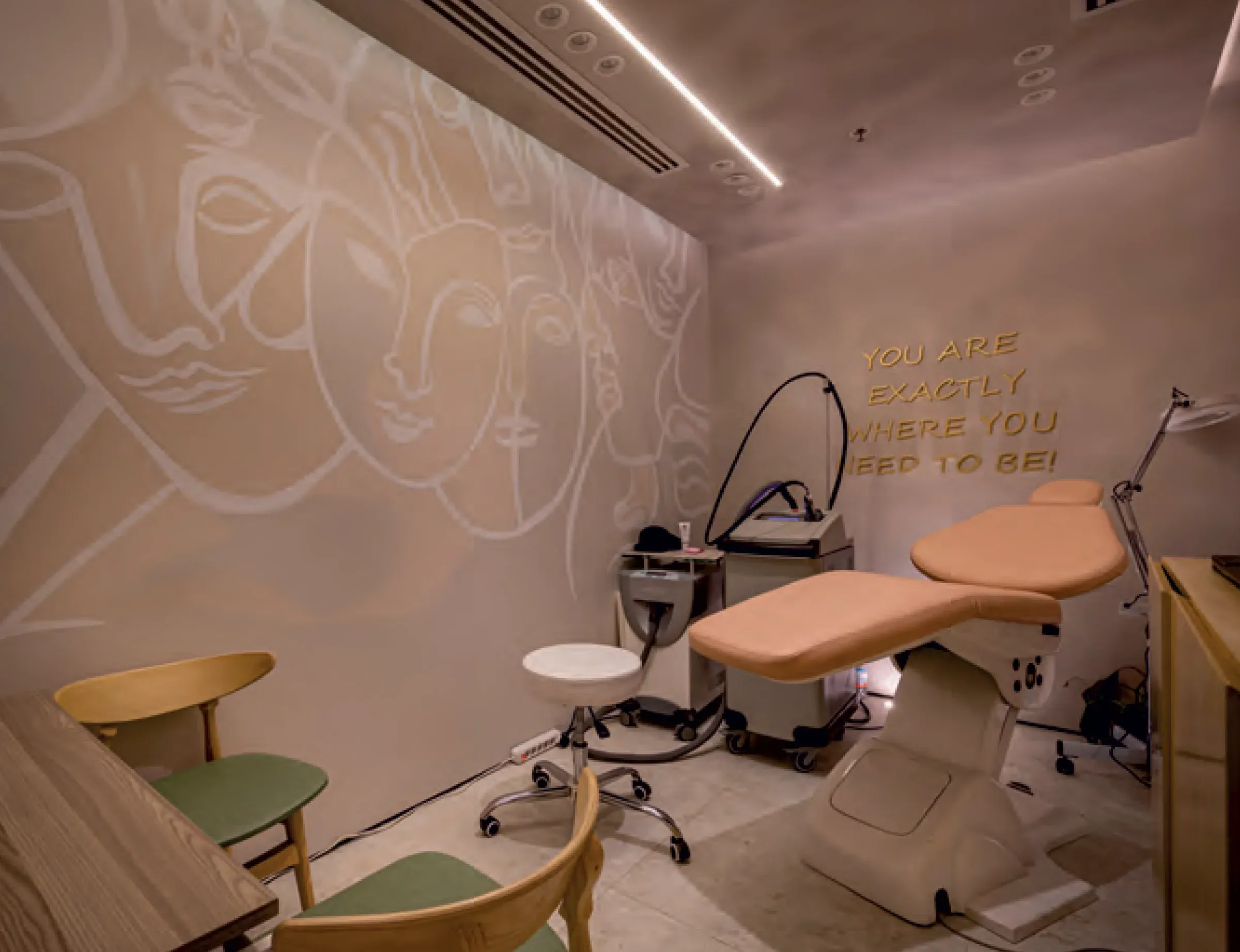 Treatment room with peach chair, laser unit and line-art wall mural