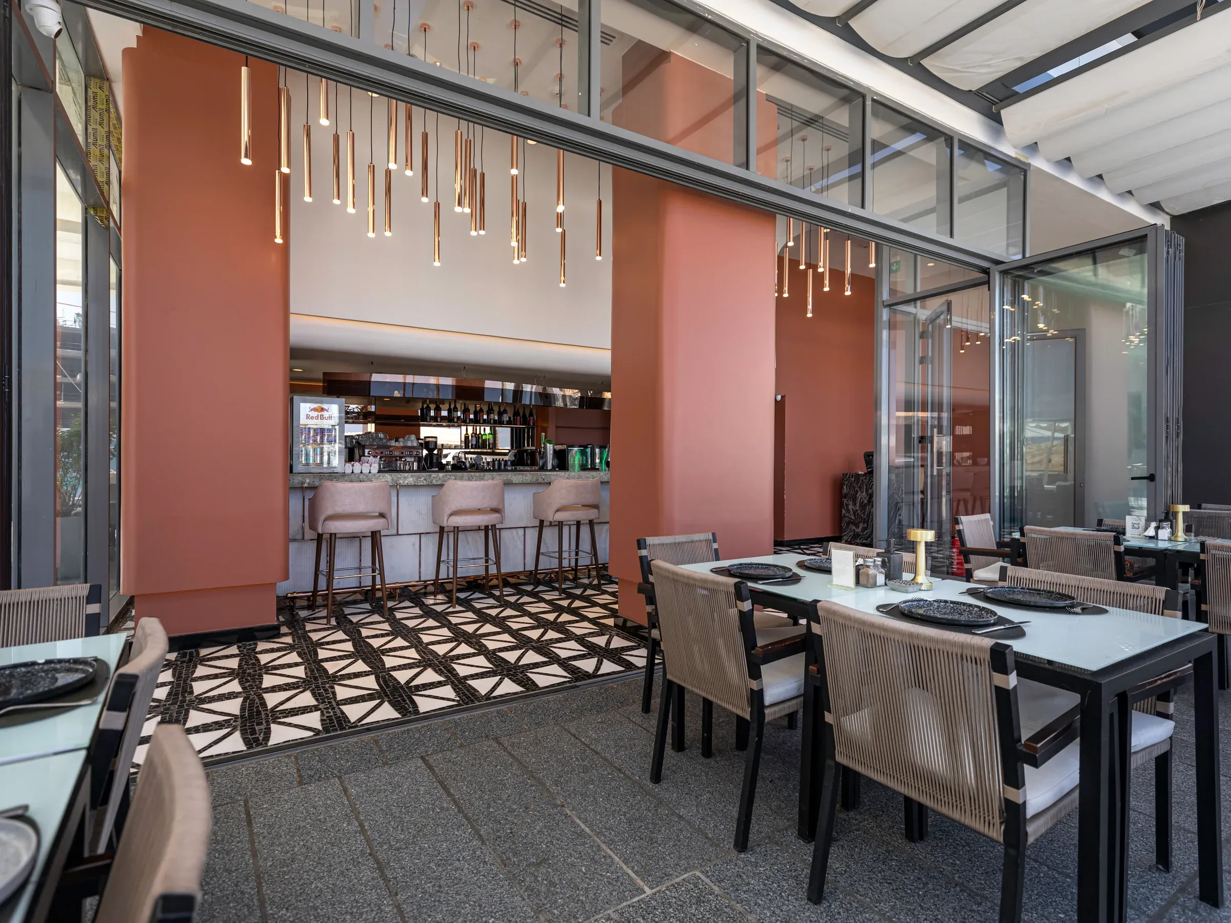 Terrace dining table facing the bar between terracotta columns