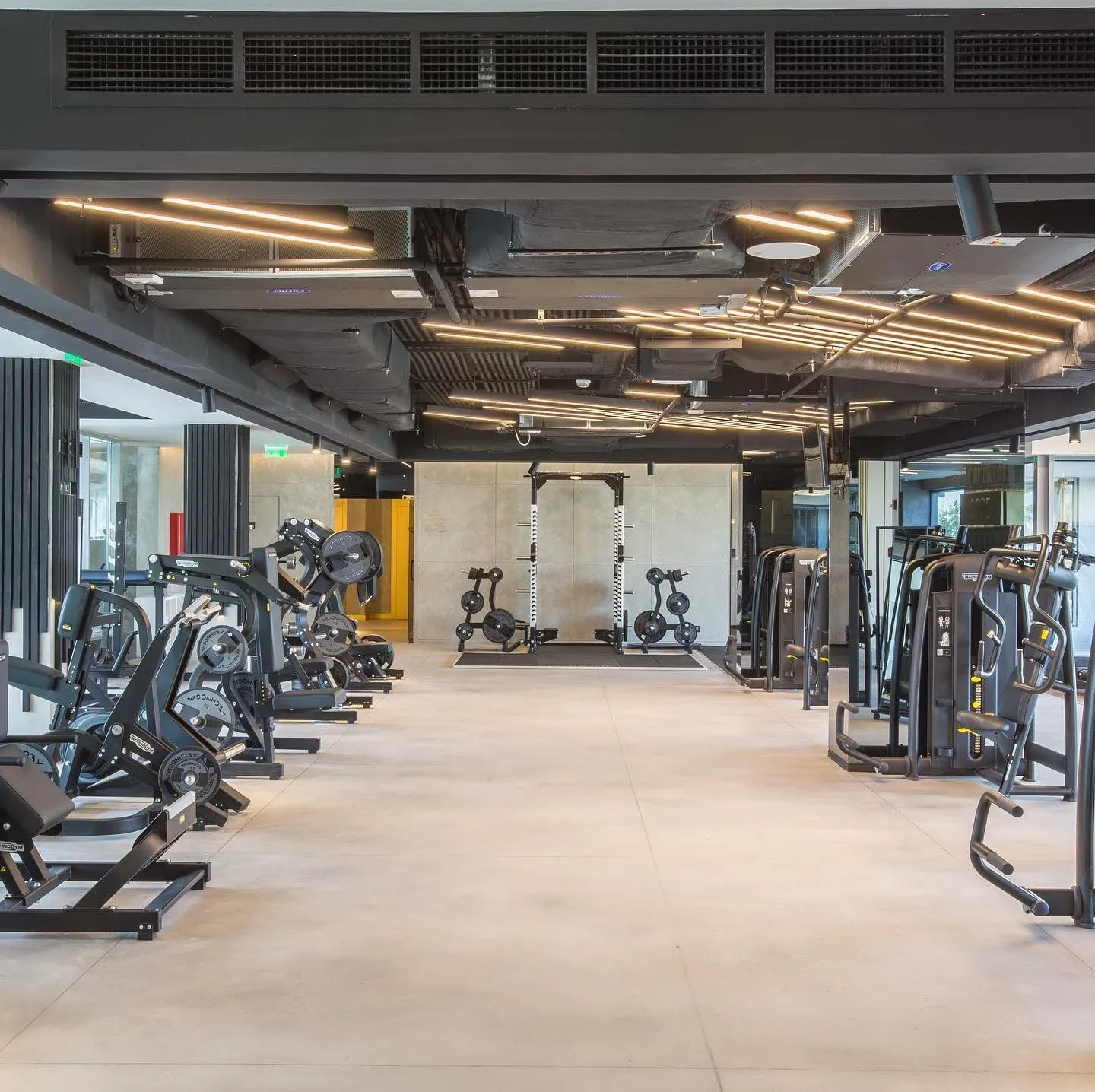 Gym floor with strength machines under an exposed services ceiling