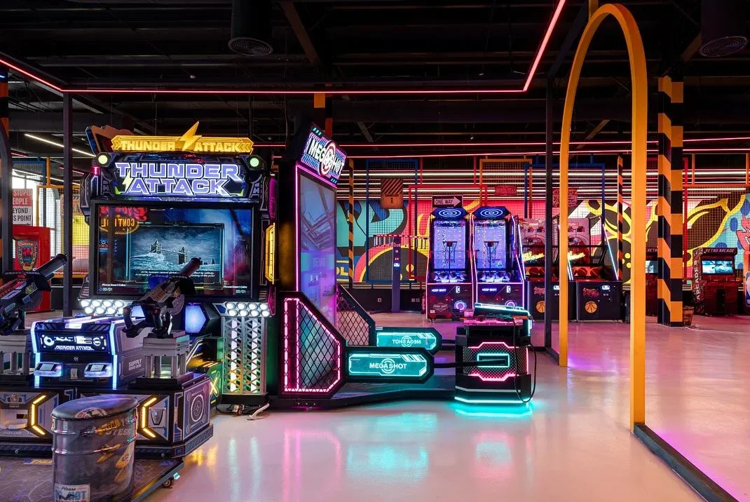 Arcade machines with neon framing and an orange arch