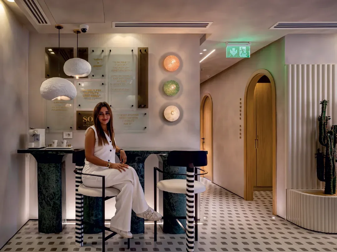 Waiting-area bar with green marble base, striped stools and an arched doorway