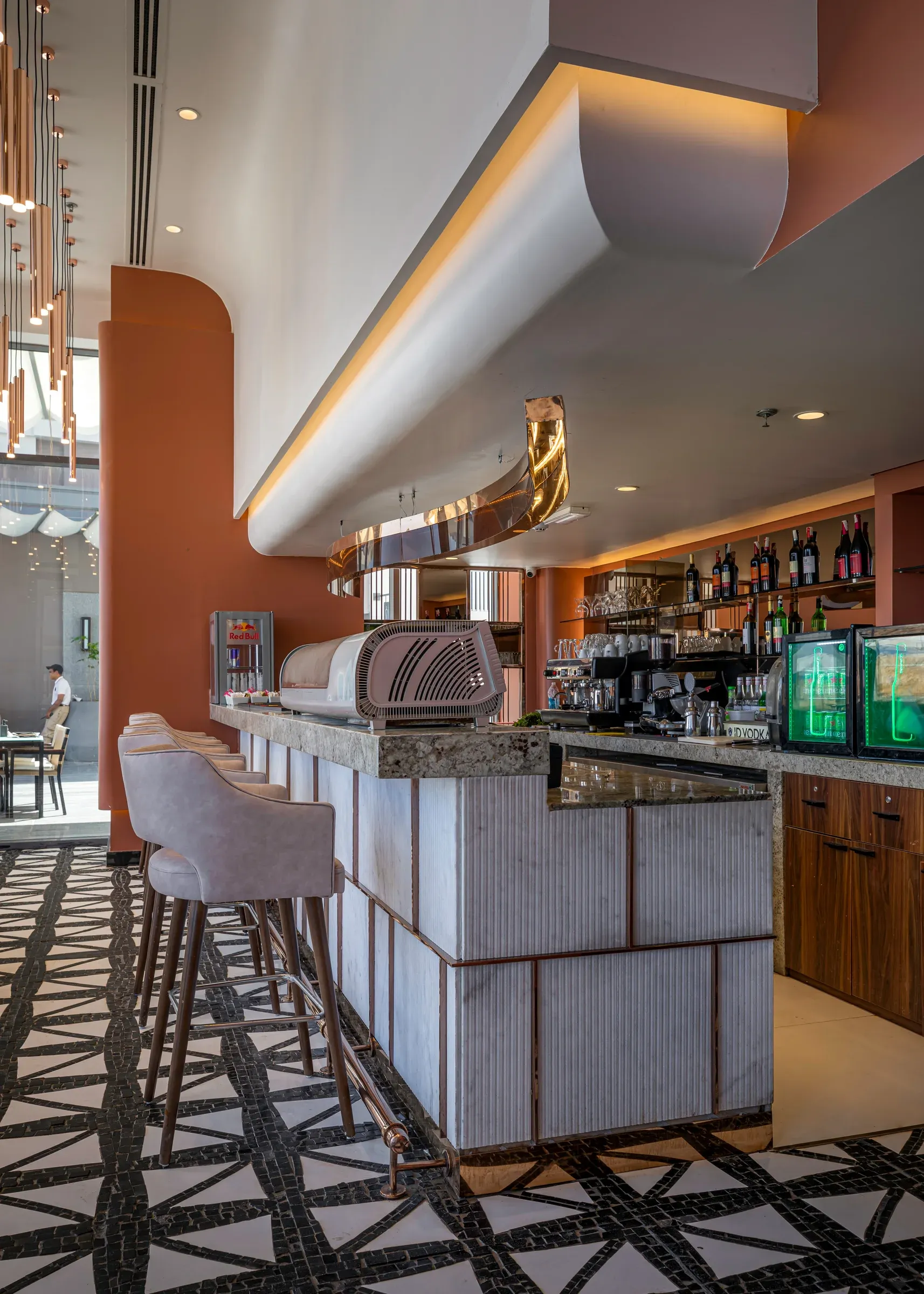 Stone-faced bar with tall stools beneath a curved plaster soffit