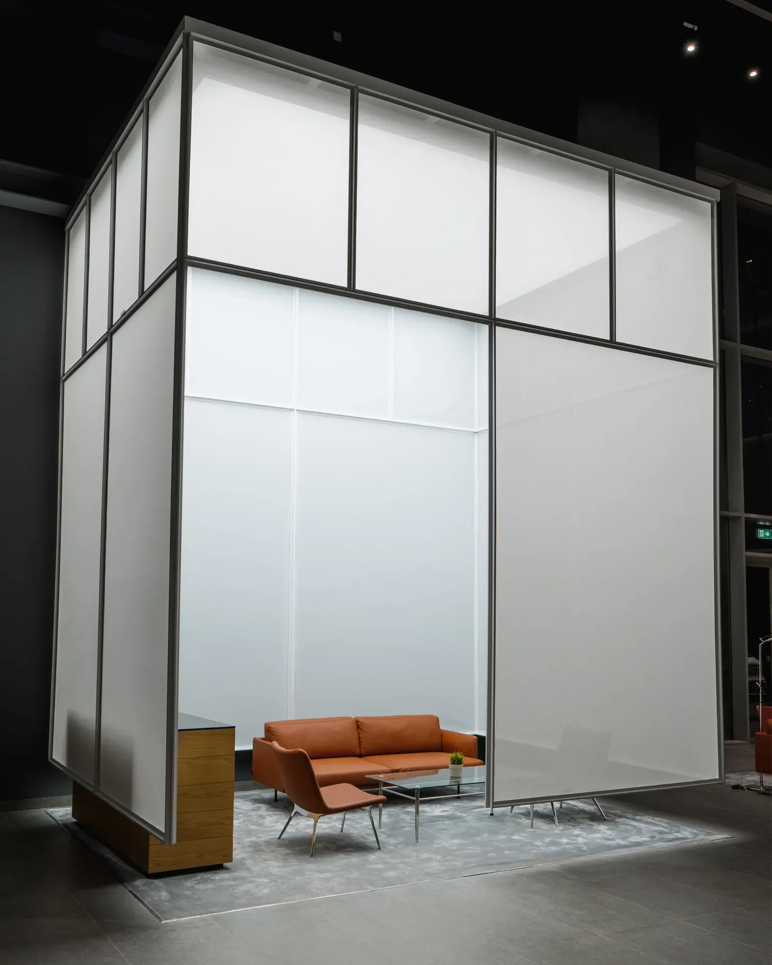 Frosted glass volume with an orange sofa inside the showroom