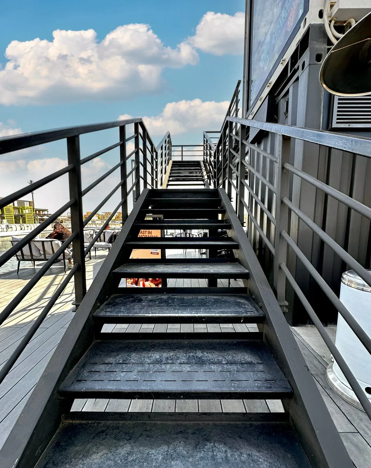 Steel staircase rising to the upper level of the cafe