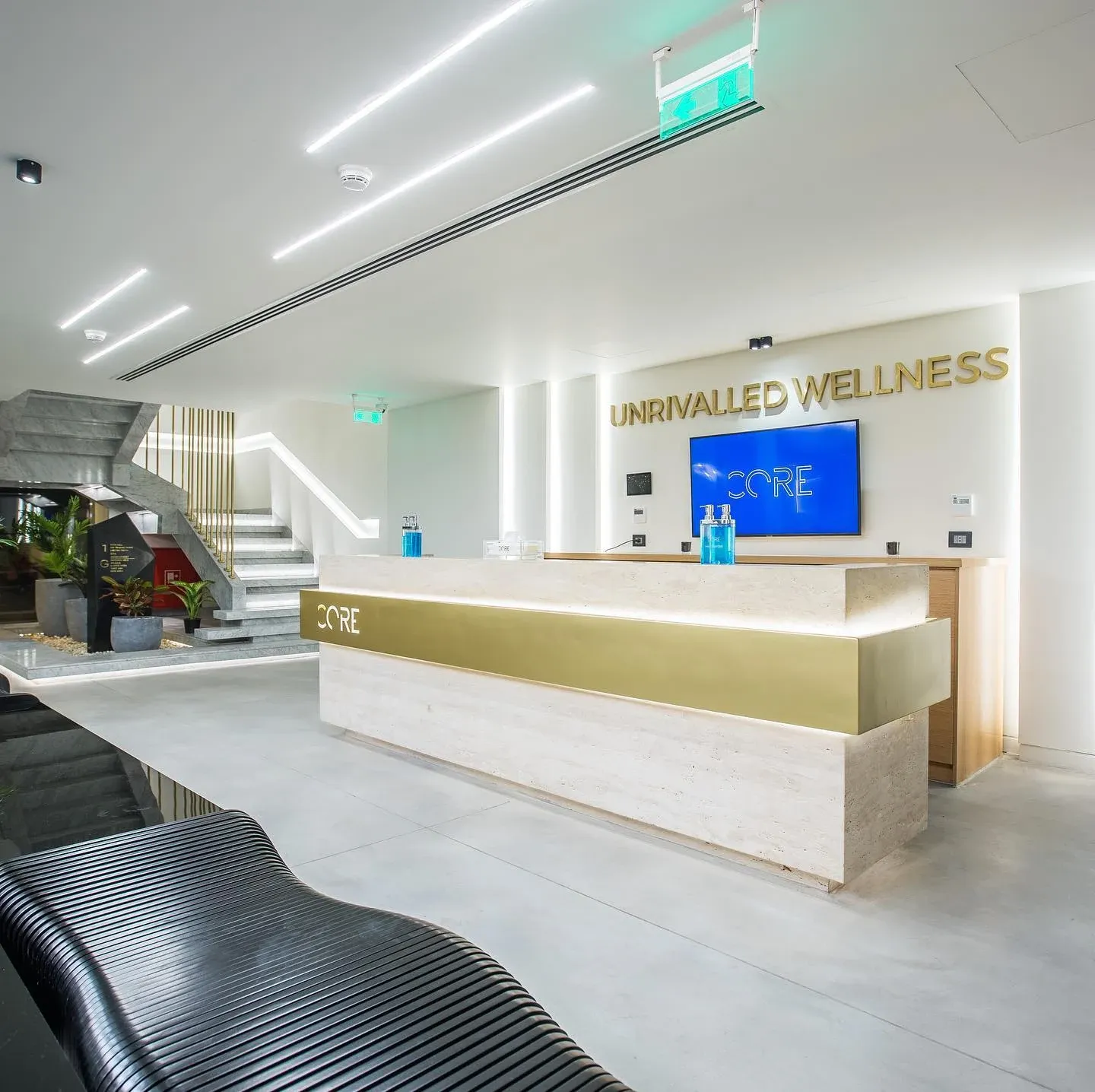 Reception desk with gold-edged counter, wall sign and staircase behind