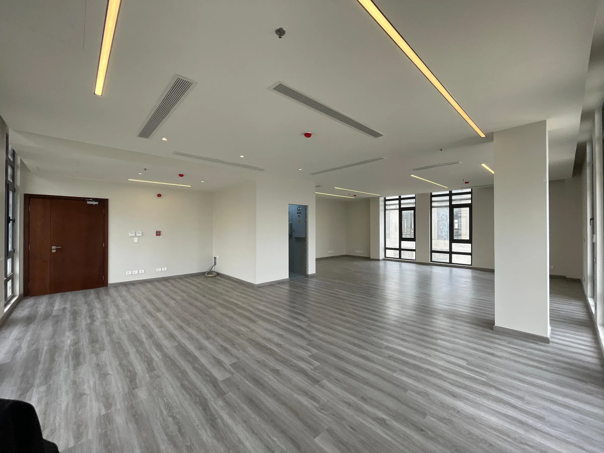 Office floor with a timber-brown door at left and a column in view
