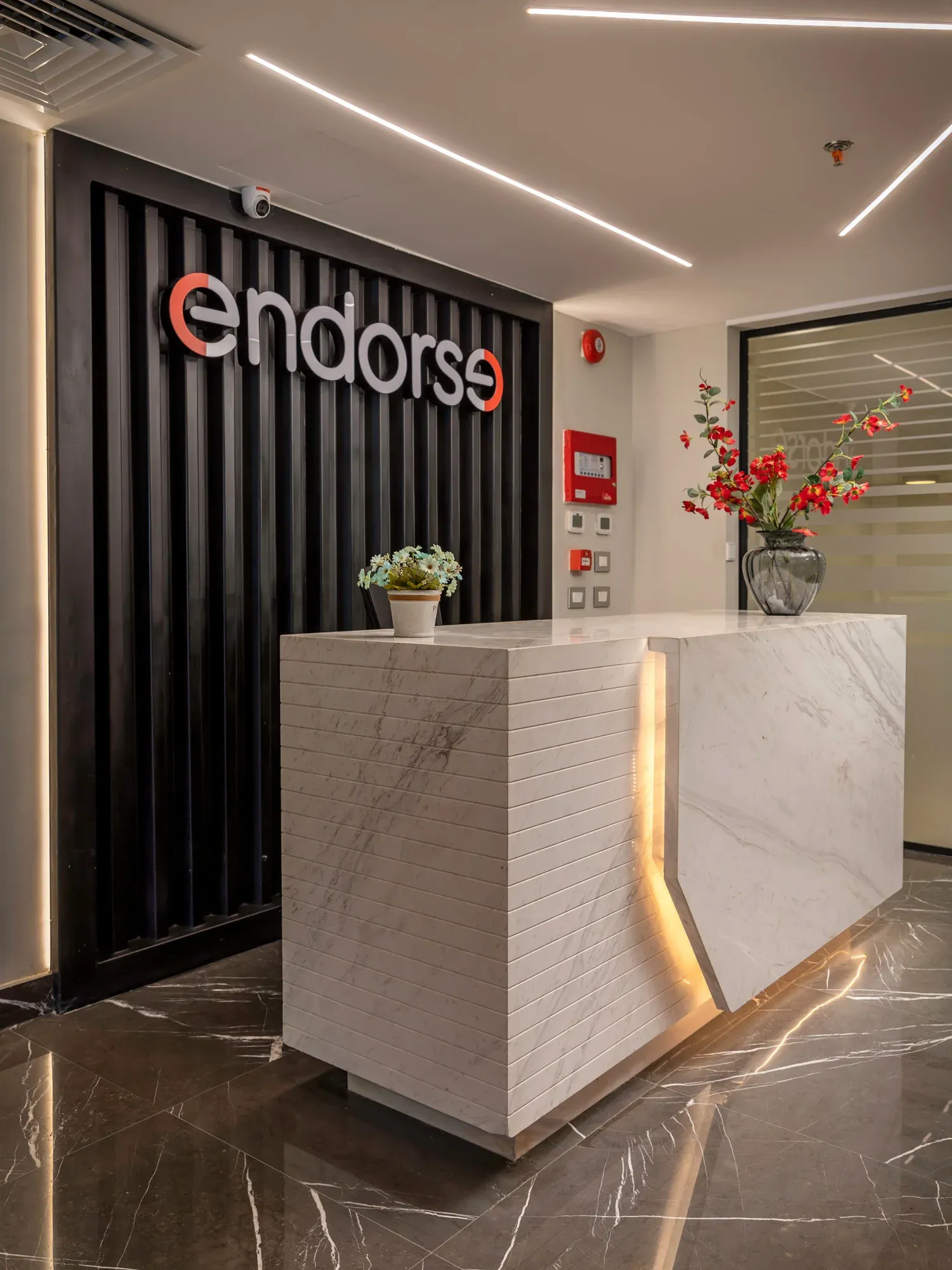 Close view of the reception desk, logo and flower arrangement