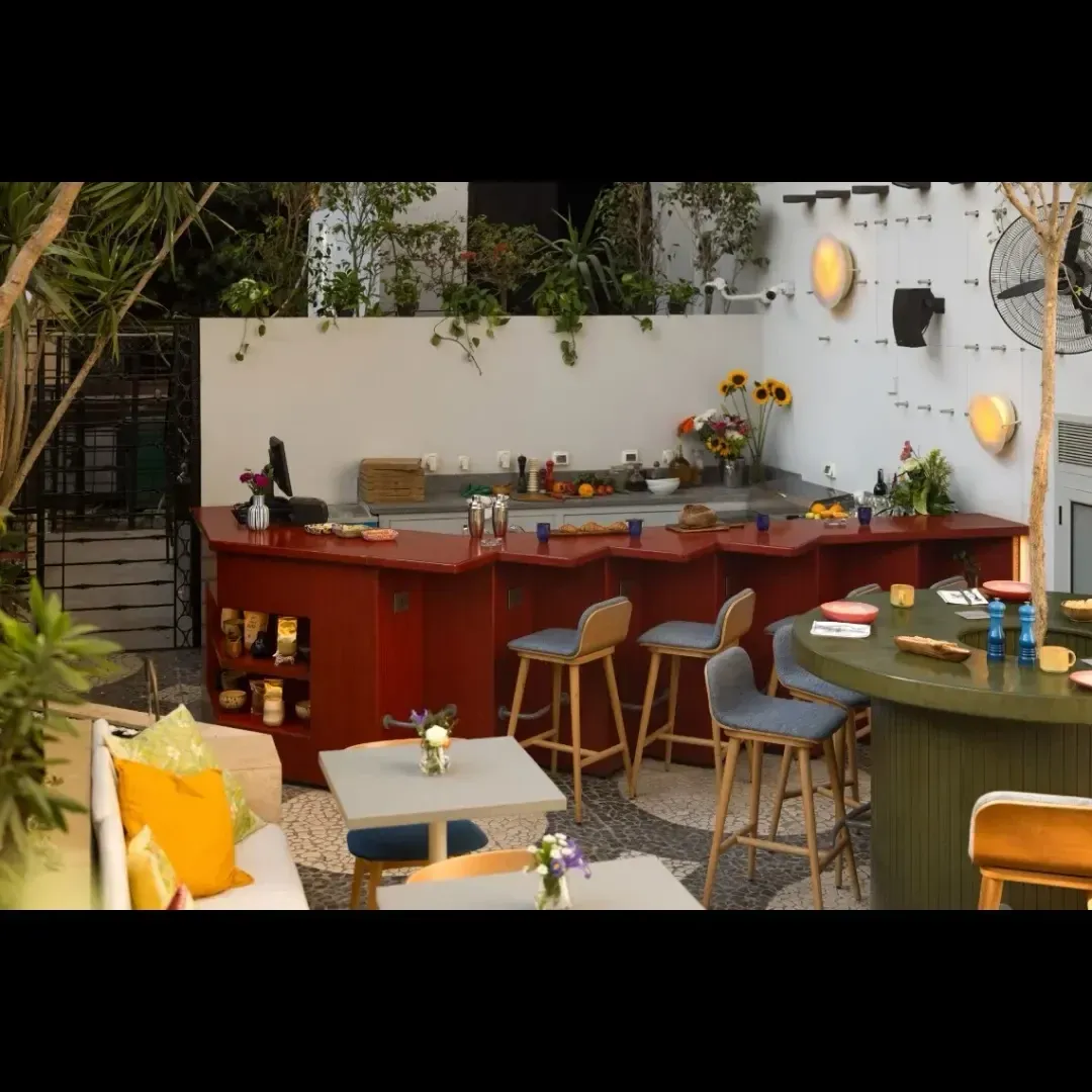 Bar counter and stools with the courtyard wall behind