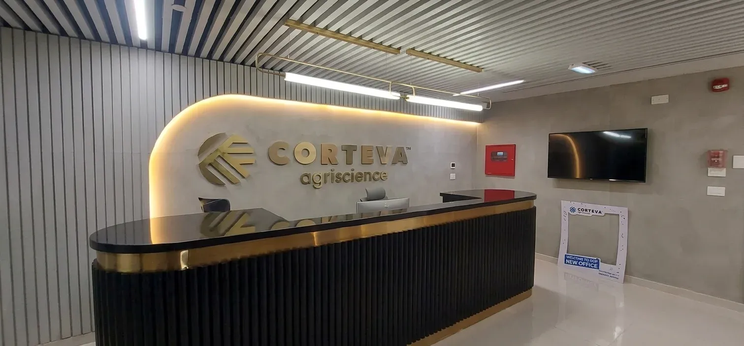 Reception desk with black fluted front, brass trim and Corteva sign