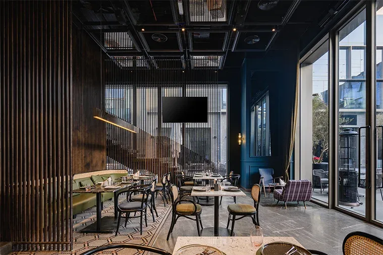 Dining area with timber fins, green banquette and floor-to-ceiling glazing