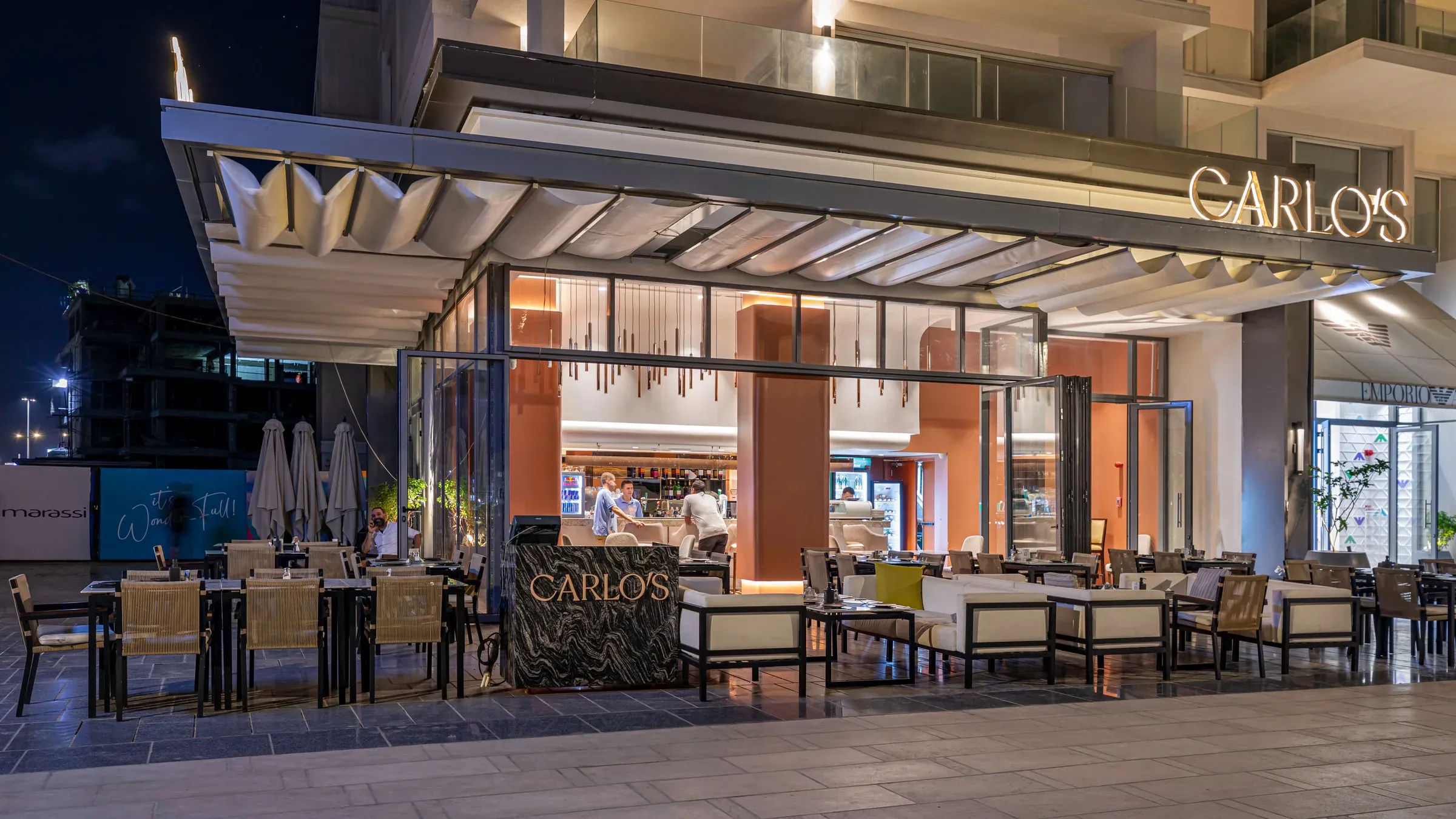 Carlo's frontage at night with canopy and diners on the terrace