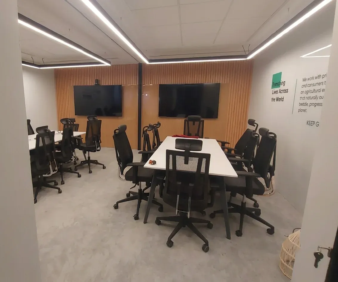 Meeting room with white table, black chairs and timber slat wall