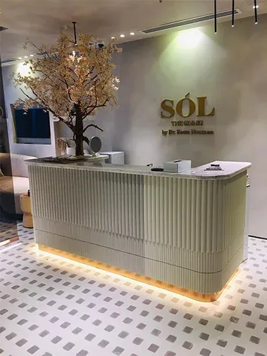 Reception desk with fluted front and warm under-lighting, logo on the wall