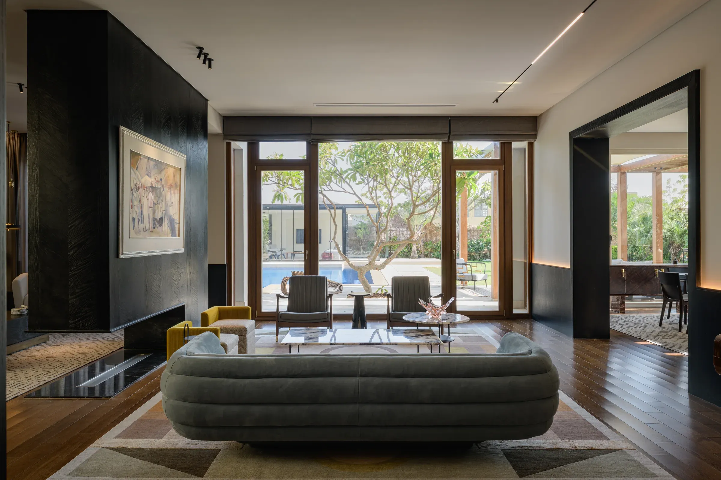 View over the curved sofa towards timber garden doors and the pool