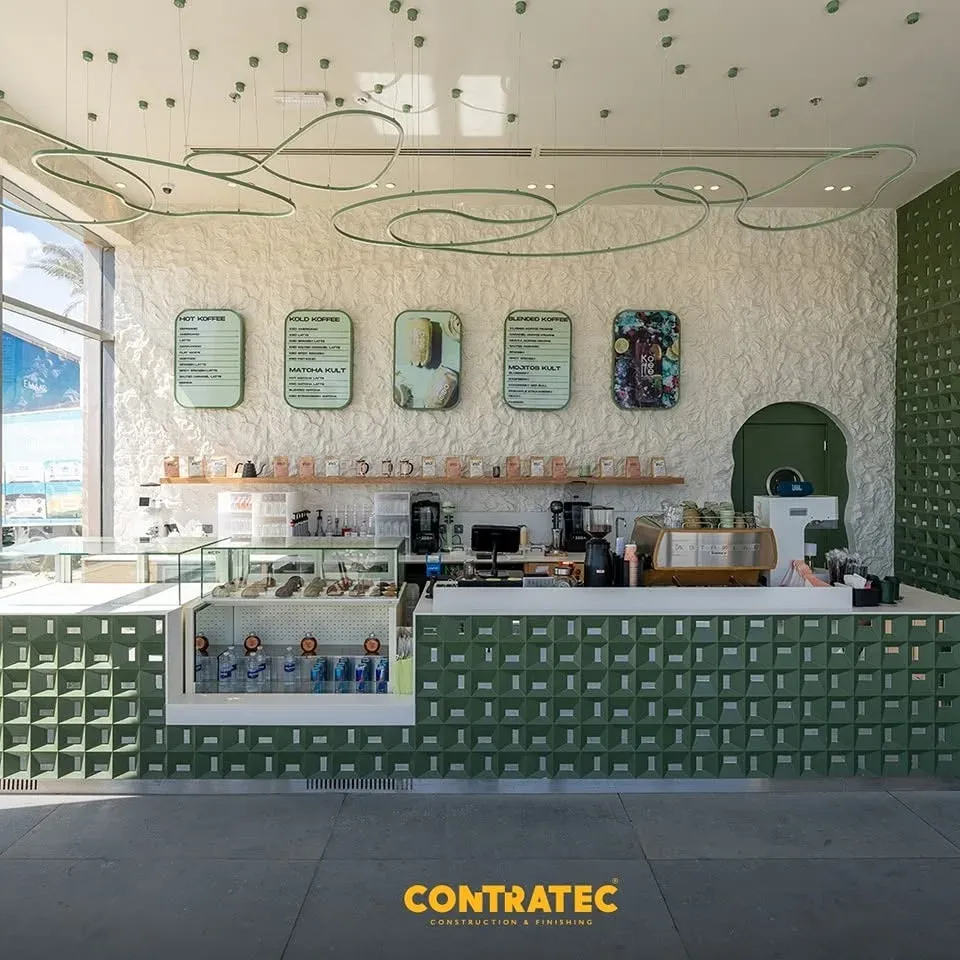 Counter clad in green tiles with menu boards and a looping line ceiling