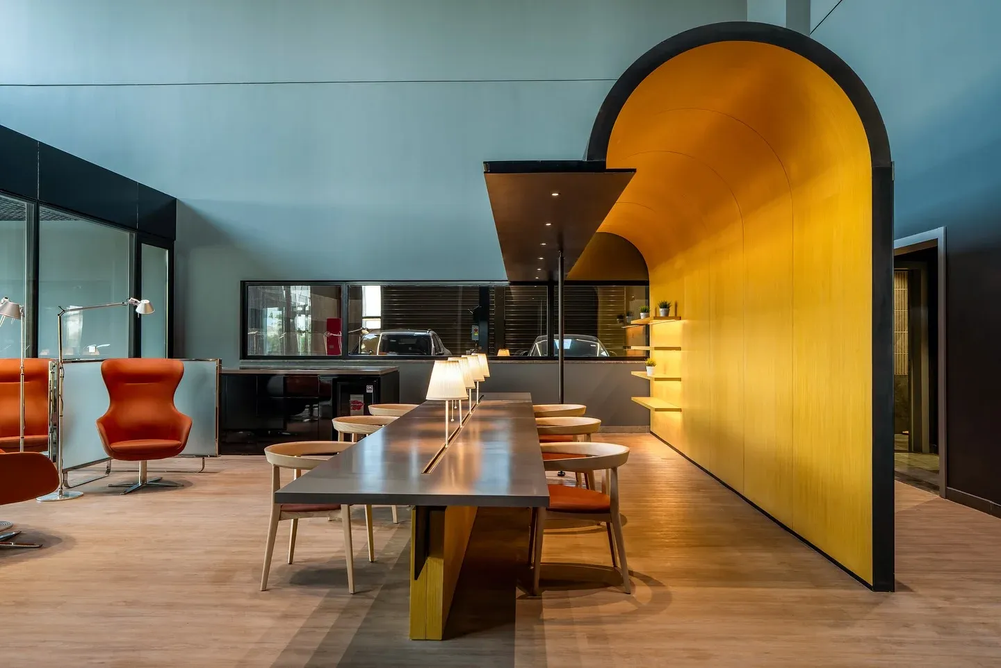 Lounge with a yellow timber arch and a long table with lamps