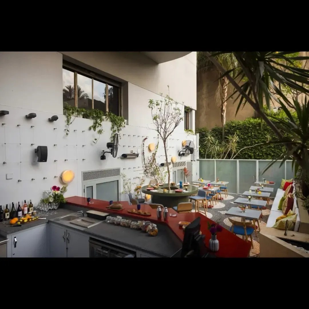 Courtyard with open bar and mosaic floor below a white wall