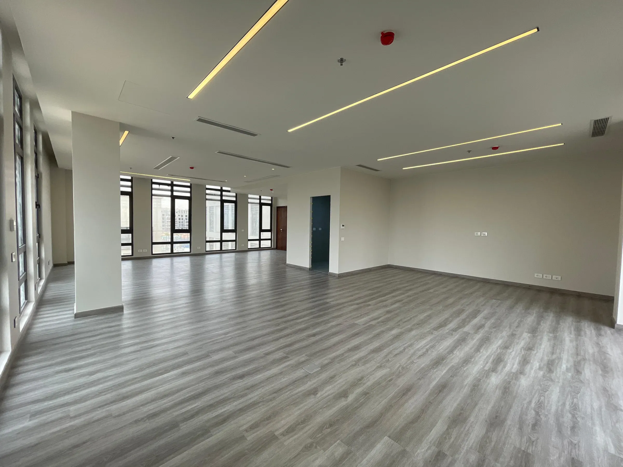 Open floor with a central column and angled light strips overhead