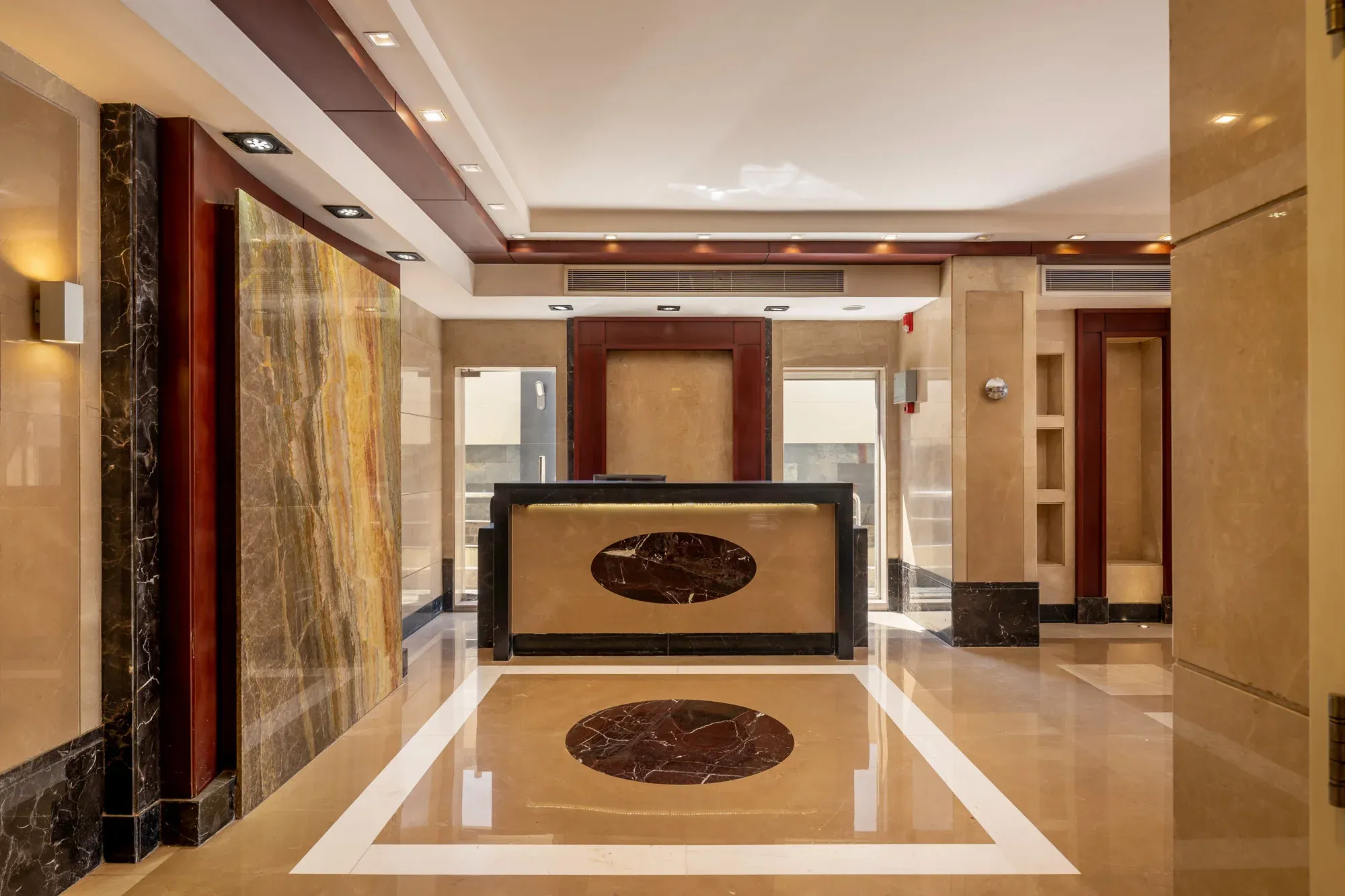 Reception desk and onyx feature wall across a polished inlaid floor