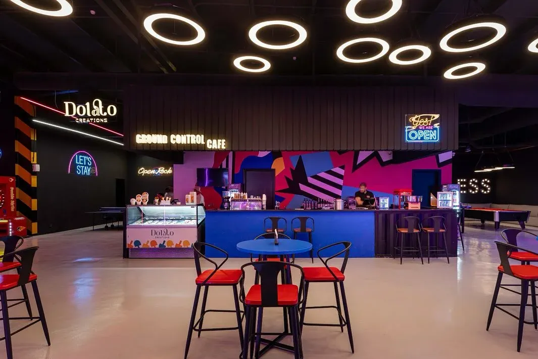 Ground Control cafe counter with ring lights overhead and red stools