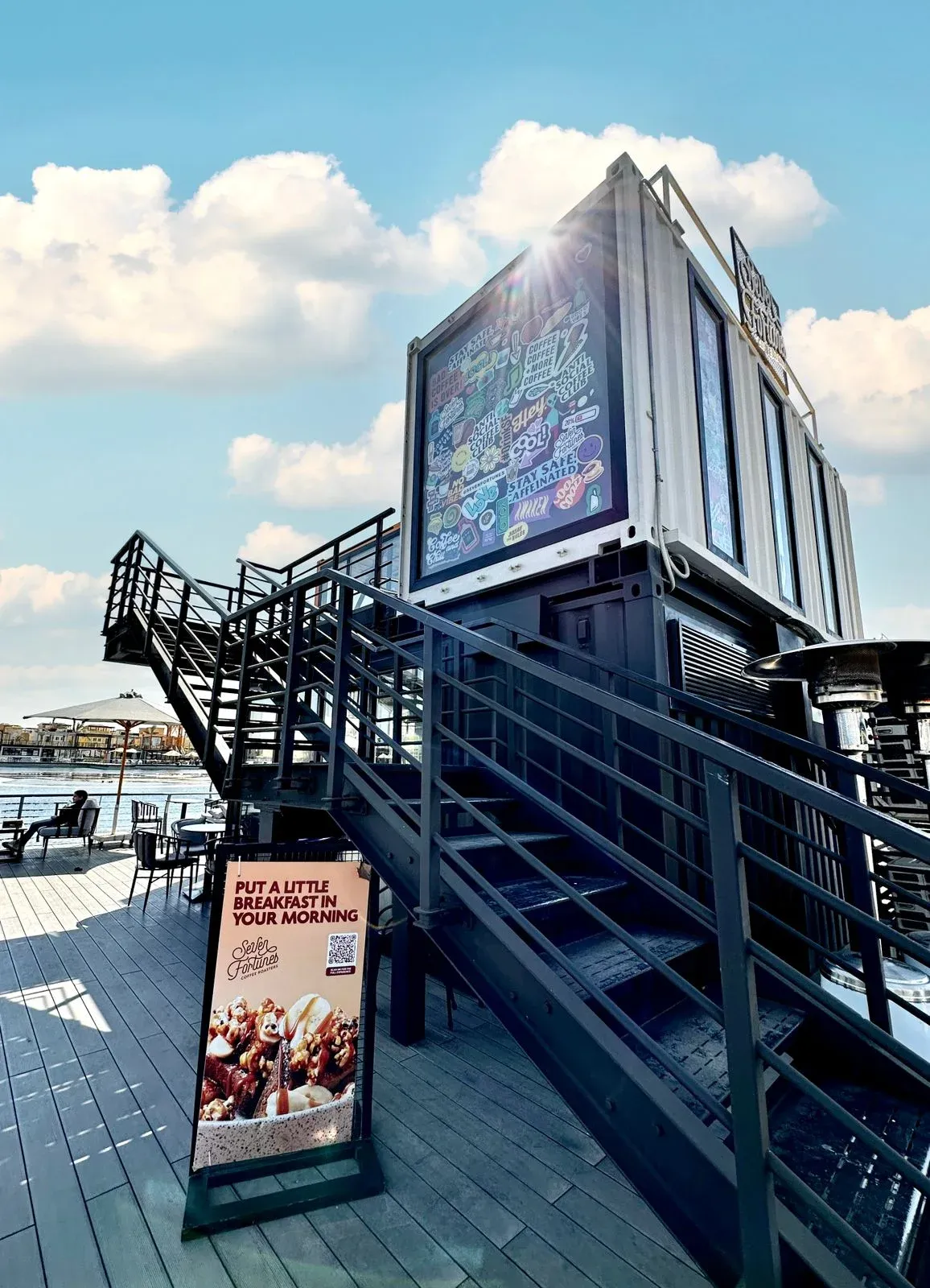 Steel stairs and railings up the side of the cafe with a sandwich board