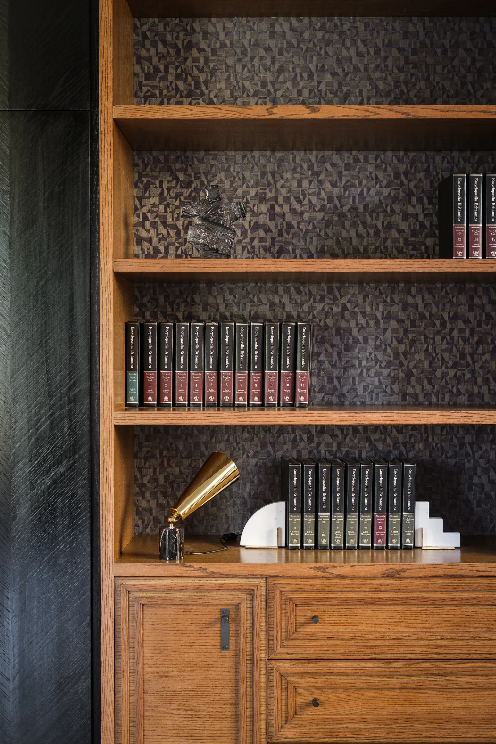 Timber bookshelf with books and a small lit lamp