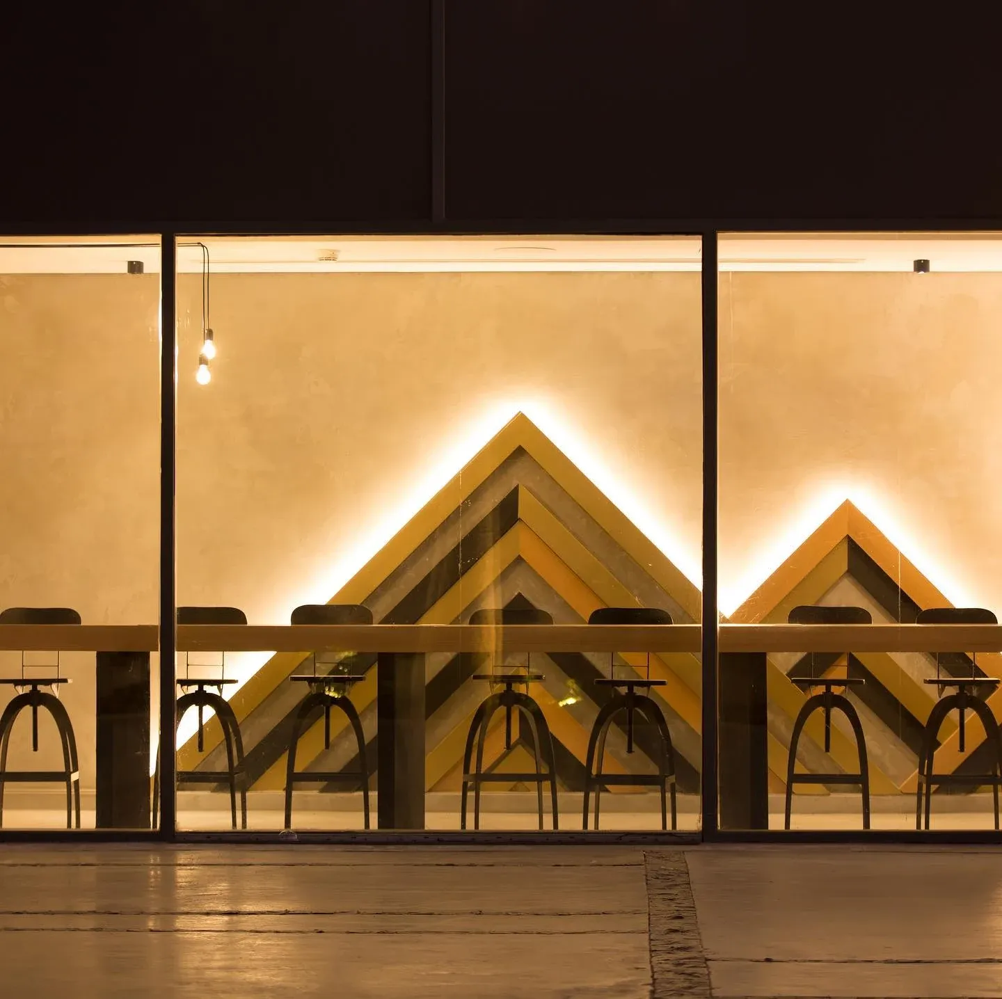 Glazed studio with a timber chevron wall feature and lit slot
