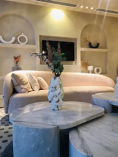 Lounge sofa and sculpted marble coffee table below arched wall niches