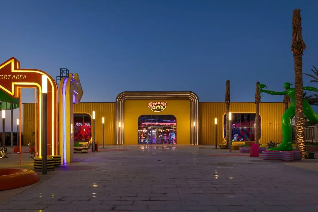 Yellow entrance gate outlined in neon at dusk