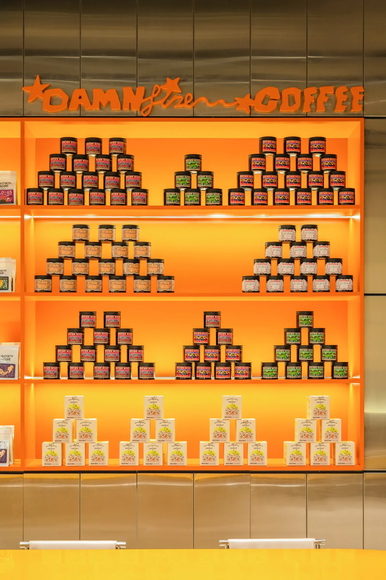 Orange backlit shelves of coffee tins, close view