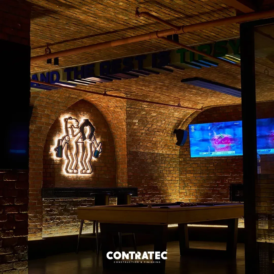 Pool table and camel logo against the lit brick wall, wider view