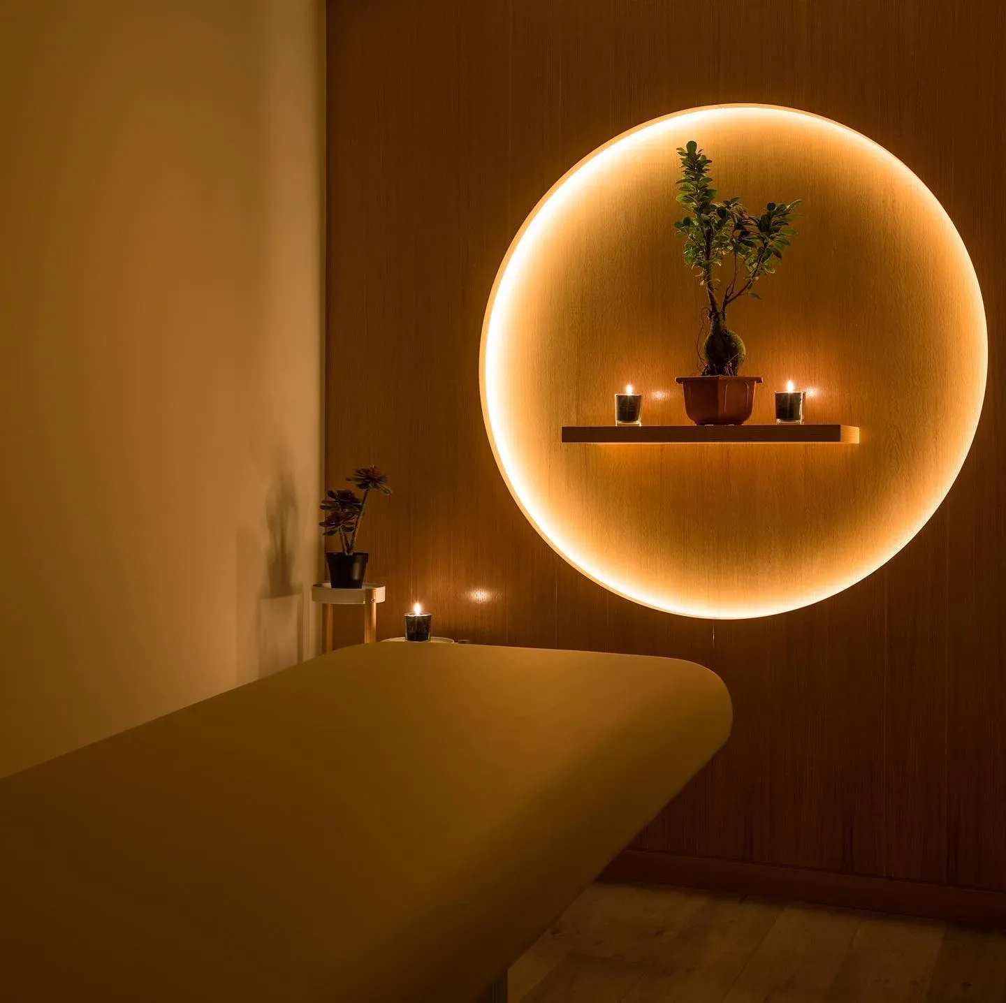 Treatment room with circular backlit panel, small plant and candles