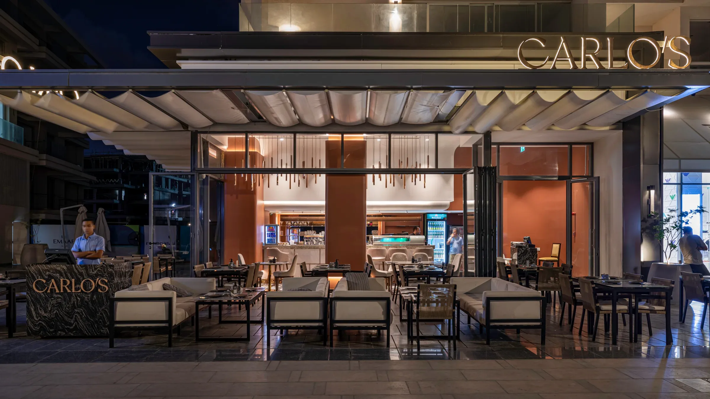 Wide night view of terrace seating beneath the Carlo's canopy