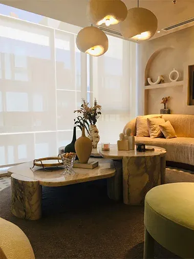 Window seating area with pendant lights and round marble tables