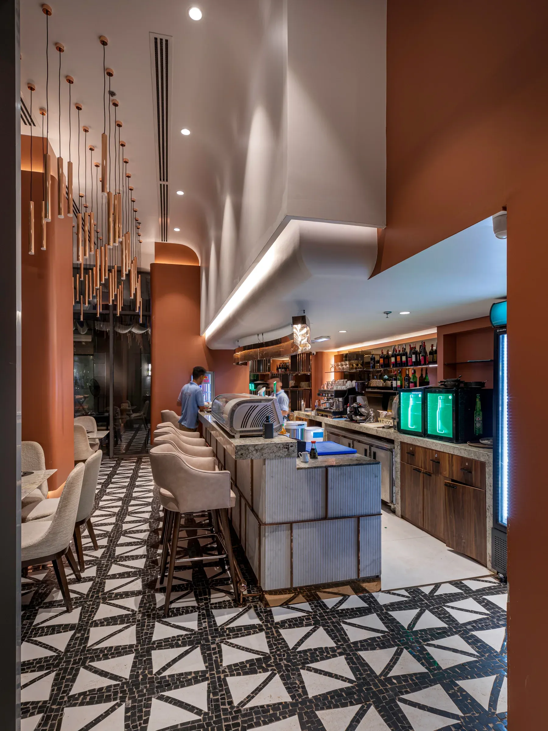 Interior with bar, diners at the counter and a geometric tiled floor
